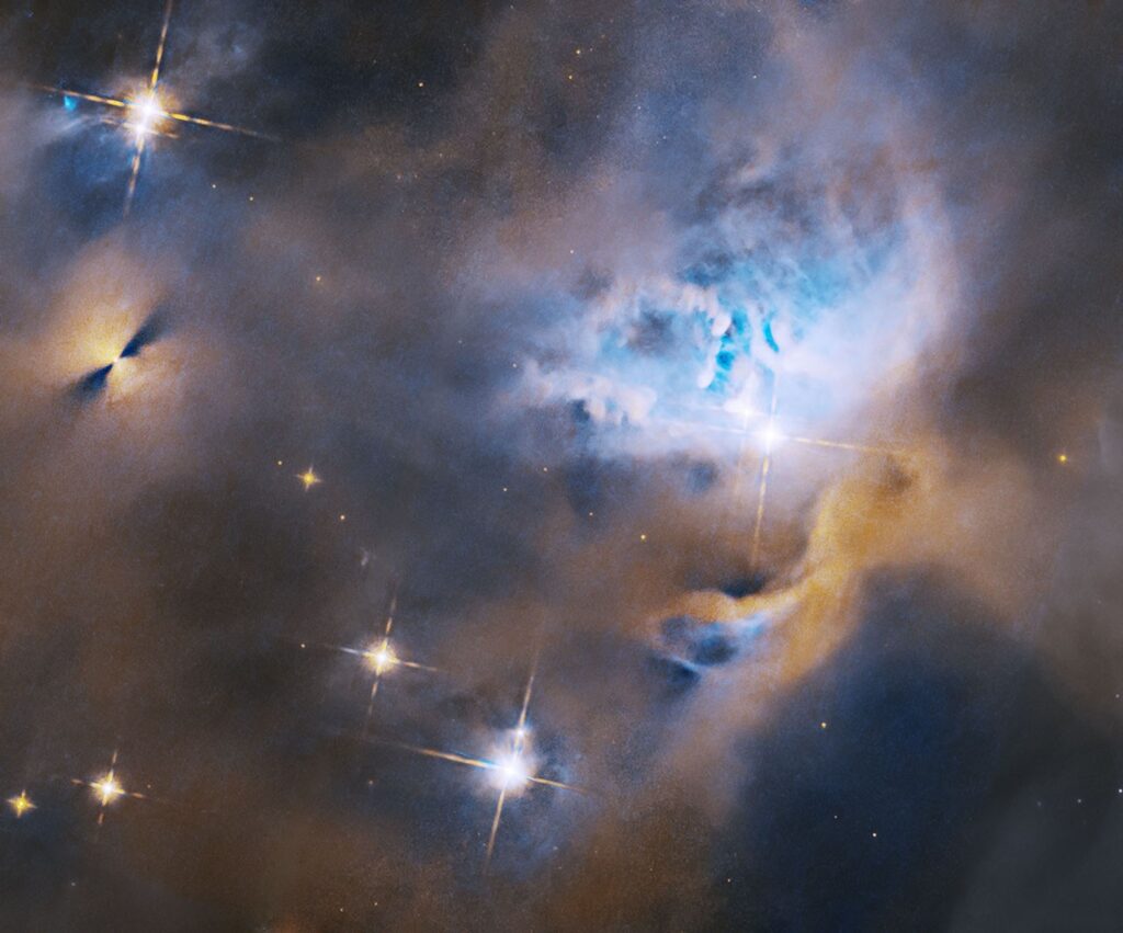 A nebula, protostar, and planet-forming disk shine in an image from the Hubble telescope.